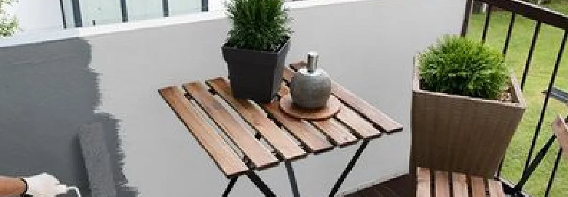 Person streicht Balkonwand grau